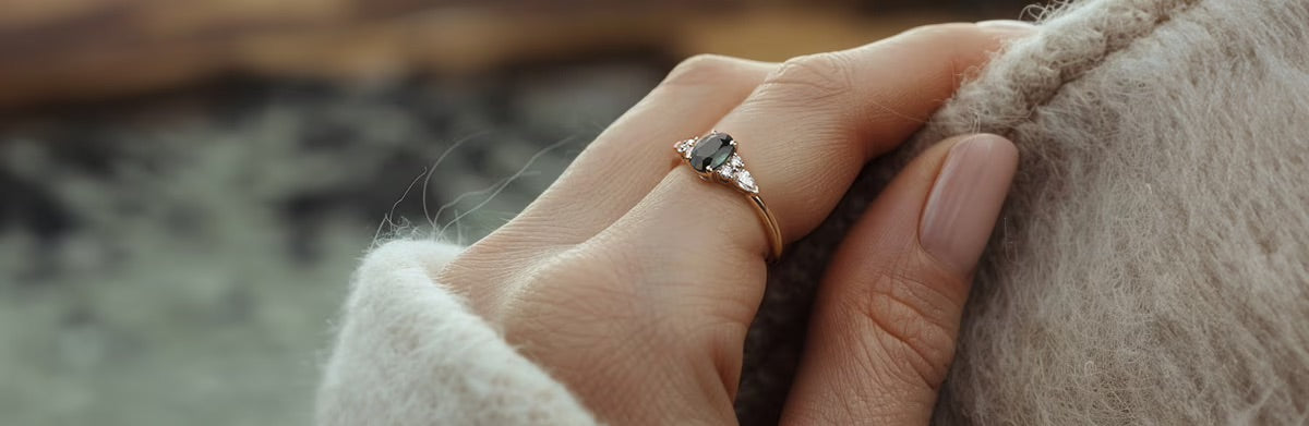 Main avec bague Quitterie saphir vert